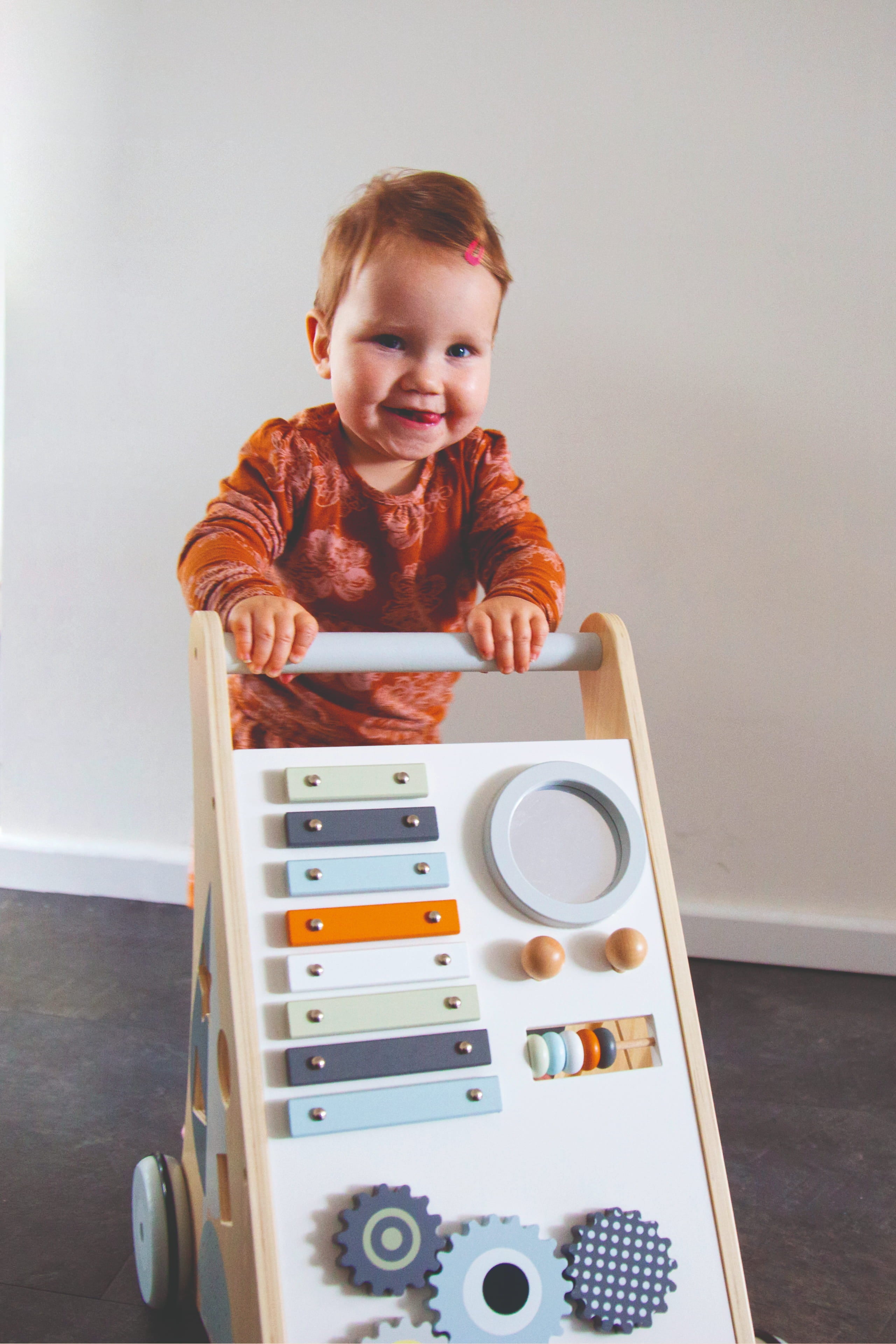 Petit garçon qui joue avec le chariot d’activités bébé en bois avec jeux d’éveil