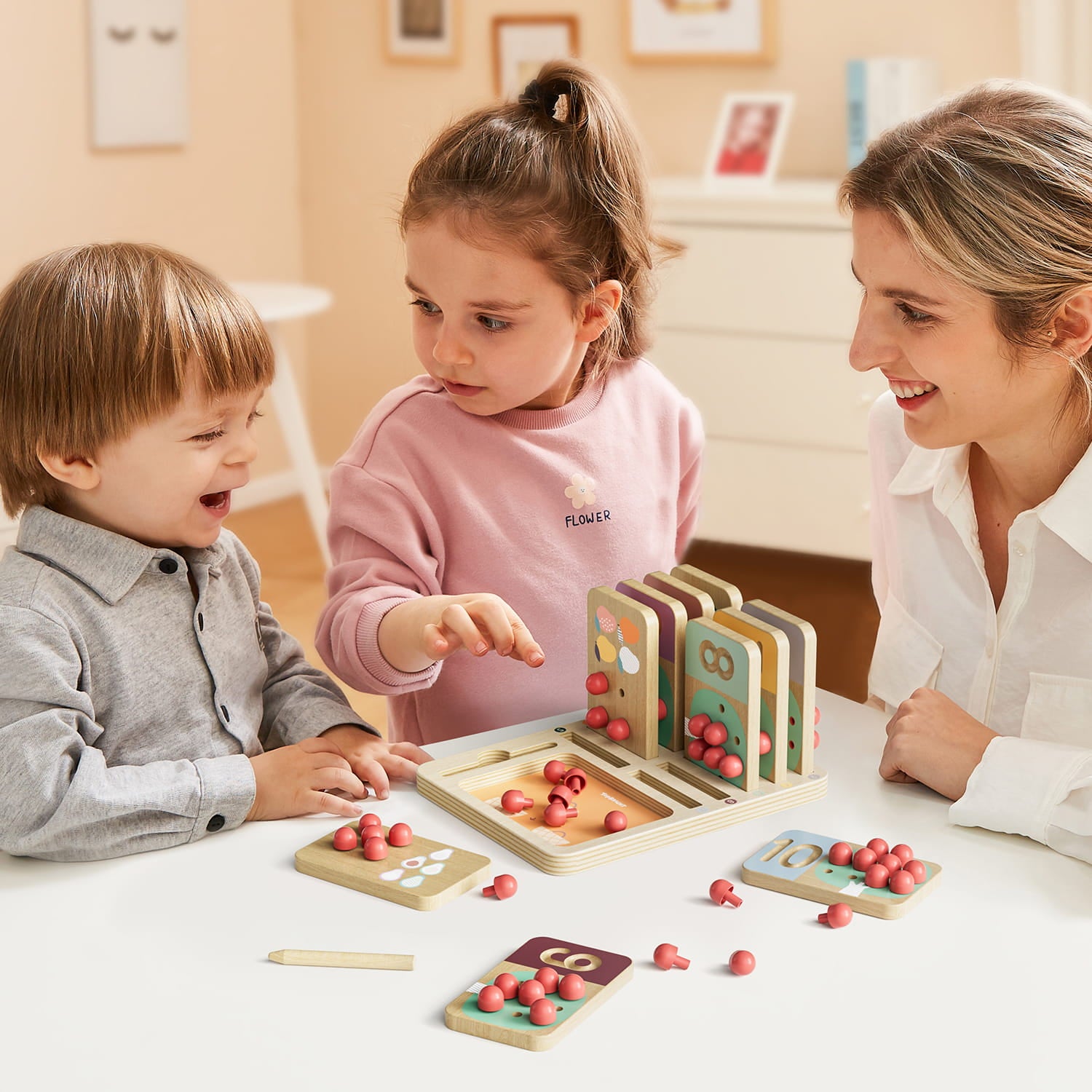 Maman et ses enfants qui jouent avec le jeu éducatif enfant chiffres bois arbres fruitiers