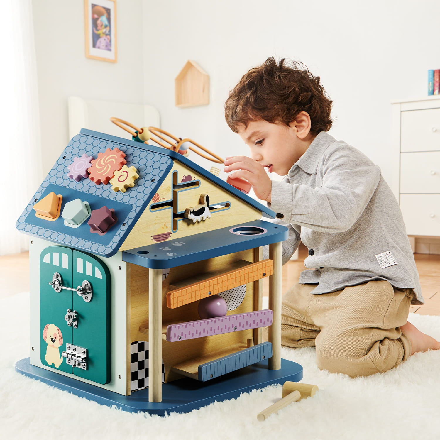 Enfant qui joue avec la maison d’activités bébé 12 en 1 éducative interactive