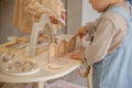 Enfant qui joue avec la table d’activité enfant en bois avec jeux interactifs
