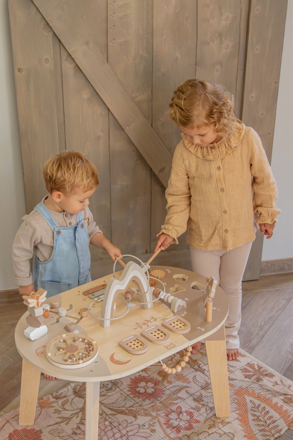 Deux enfants jouant avec la table d’activité enfant en bois avec jeux interactifs