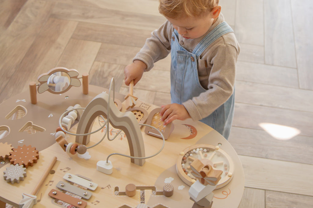 Enfant qui joue avec le maillet de la table d’activité enfant en bois avec jeux interactifs
